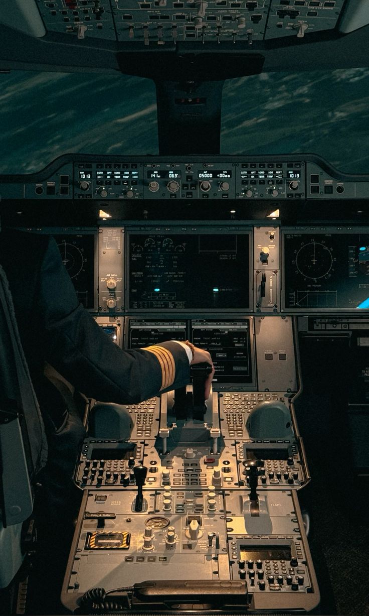 Captain's hand on the thrust levers of an airliner flight deck in cruise